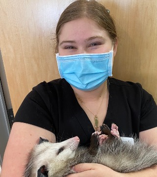 Maya holding a opossum.